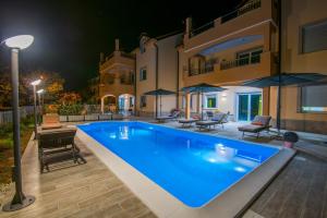 a swimming pool in front of a house at night at Villa Ljubica 2 in Vodice