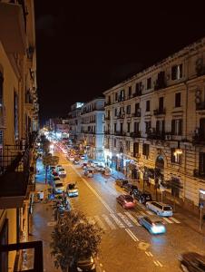 una concurrida calle de noche con coches y edificios en PèPè Bed & Breakfast en Nápoles