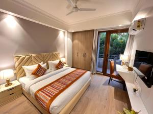 a bedroom with a bed and a desk and a television at Hotel Gianmala Residency South Extension near AIIMS Delhi in New Delhi