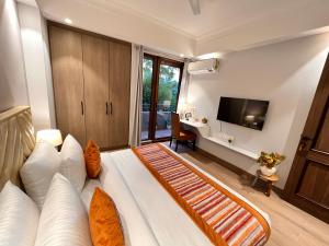 een slaapkamer met een bed, een bureau en een televisie bij Hotel Gianmala Residency South Extension near AIIMS Delhi in New Delhi