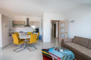 Villa Ljubica 2 في فوديس: غرفة معيشة بها أريكة وطاولة وكراسي صفراء