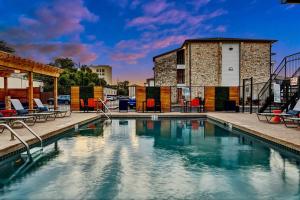 a swimming pool with chairs and a building at Your Modern 2B Getaway - W/D, Pool, Prkg - 10min to DTWN in Austin