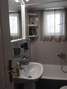 a bathroom with a sink and a bath tub at Marilena's Apartment in Rafina