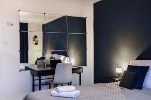 een kamer met 2 bedden, een bureau en een spiegel bij Deluxe! Hbf-Nähe mit Kingsize-Bett, 65 m2 in Duisburg