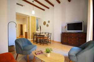 a living room with a tv and a table and chairs at Sevilla centro- Sol - Acogedor y luminoso in Seville