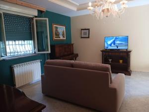 een woonkamer met een bank en een flatscreen-tv bij oasi della freschezza in Montelepre