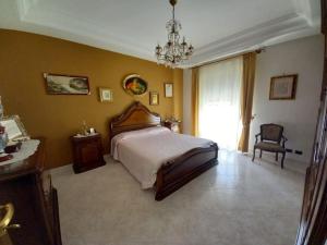een slaapkamer met een groot bed en een kroonluchter bij oasi della freschezza in Montelepre