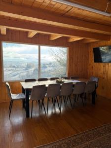 a dining room with a table and chairs and a large window at Panoramic House in Mărişel