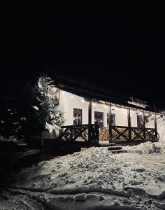 a building in the snow at night at Panoramic House in Mărişel