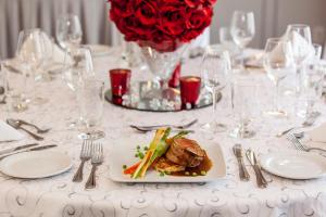 een tafel met een bord eten en een vaas met rozen bij Holiday Inn Laval Montreal, an IHG Hotel in Laval