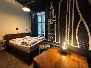 a bedroom with a bed and a table and a window at Imaginary Hostel in Tallinn