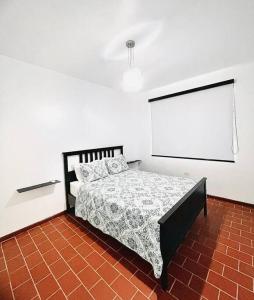 a bedroom with a bed in a white room at Sweet Sunset I - Aguadilla’s Street Art District in Aguadilla