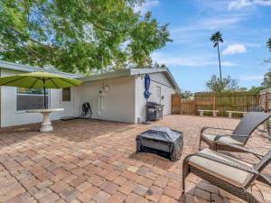 um pátio com 2 cadeiras e um guarda-sol em Bradenton Banyan Bungalow em Bradenton