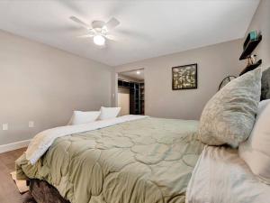 - une chambre avec un lit et un ventilateur de plafond dans l'établissement Bradenton Banyan Bungalow, à Bradenton