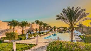 a resort pool with lounge chairs and palm trees at Gemma Resort in Marsa Alam City +37 photos