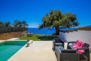 a patio with two chairs and a swimming pool at Olive Zen Villa Zante in Zakynthos Town
