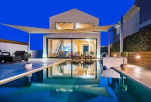 a house with a swimming pool at night at Olive Zen Villa Zante with Private Pool & Sunrise Sea View in Zakynthos