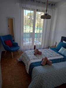 a bedroom with a bed and a blue chair and a window at +++++ brand new flat 4 persons near Hotel Martinez, center and Palais des festivals +++++ in Cannes