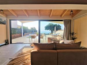 a living room with a couch and a view of the ocean at Olive Zen Villa Zante in Zakynthos Town