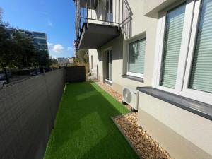 a yard with green grass on the side of a building at Szpakowa Luxury Apartment in Kraków