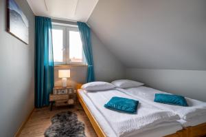 a bedroom with a bed with blue pillows on it at Karkonoskie Zacisze in Mysłakowice