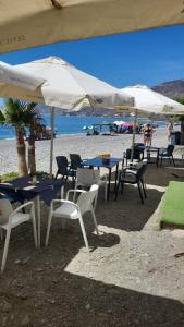 a group of tables and chairs with umbrellas on the beach at Vistas al Mar Mediterraneo in Melicena