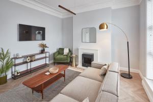 Cosy Coastal Apartment 1 في بريدلينغتون: غرفة معيشة مع أريكة وطاولة