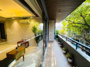 een overdekt balkon met een bank en planten bij Hotel Gianmala Residency South Extension near AIIMS Delhi in New Delhi