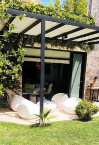 a patio with white chairs and a large window at La casa de Su in Neuquén