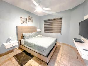 ein Schlafzimmer mit einem Bett, einem Schreibtisch und einem Fernseher in der Unterkunft Princesa de Penasco Condo B303 Sandy Beach Puerto Penasco in Puerto Peñasco + 41 Fotos