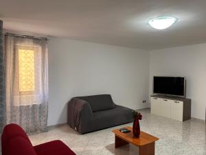 uma sala de estar com um sofá e uma televisão em A casa di Zia Ale em Brindisi