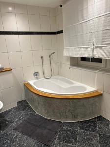 a bath tub with a shower in a bathroom at Ferienwohnung Saargauliebe in Saarburg