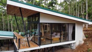 una casa en el bosque con una gran ventana en Pandanus Lodge & Retreats, 