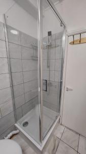 a shower with a glass door in a bathroom at Gatesden Guest House in London