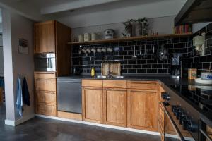 una cocina con armarios de madera y fregadero en Huize Jente en Ryptsjerk