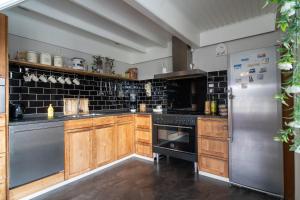 een keuken met houten kasten en een roestvrijstalen koelkast bij Huize Jente in Ryptsjerk