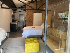 a bedroom with a bed and a couch at Maboneng The Urban Chic 346 -Unlimited WiFi in Johannesburg