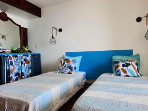 2 Betten in einem blau-weißen Zimmer in der Unterkunft Martinique La Trinité KAZAKASSY Studio plain-pied, fonctionnel et vue mer in La Trinité