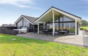 a house with glass doors and tables on a patio at Amazing Home In Bogense With Sauna in Bogense