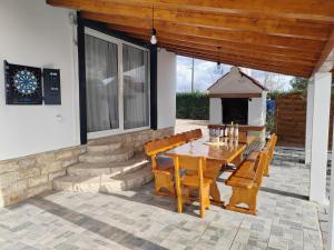 a patio with a wooden table and wooden benches at Kuća za odmor Cvita in Zadar