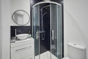 a bathroom with a shower with a sink and a toilet at Ocean View in Hornsea