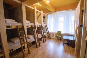 a room with several bunk beds and a table and a window at Imaginary Hostel in Tallinn