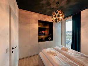 um quarto com uma cama e um lustre em AlpenLuxus' KAISER LODGE with rooftop pool & underground car park em Viena
