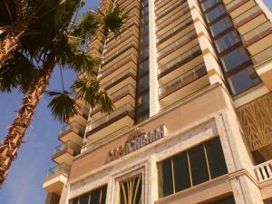 un grand bâtiment avec un palmier devant lui dans l'établissement Copacabana Jomtien Luxury Residence & Yahaha, à Jomtien Beach