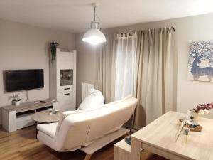 a living room with a white couch and a table at Apartamento CIR in Villanúa