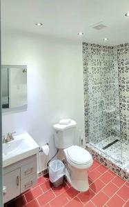 a bathroom with a toilet and a glass shower at Sweet Sunset II- Rompeolas Beach in Aguadilla