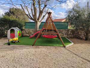 a playground with a slide and a play tent at Kuća za odmor Cvita in Zadar