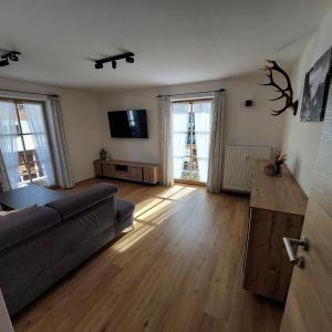 un salon avec un canapé et une télévision dans l'établissement Haus Kurparkblick Ferienwohnung Lautersee, à Mittenwald