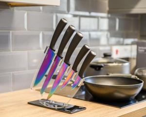 a group of knives on a counter next to a bowl at Stylish Two-bed House Birmingham sleep up-to 6 in Birmingham