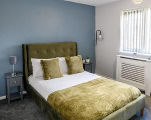 a bedroom with a large bed with blue walls at Stylish Two-bed House Birmingham sleep up-to 6 in Birmingham